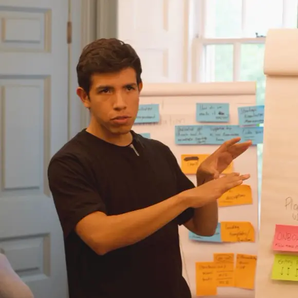 Memo Esparza presenting at a wall of workshop notes